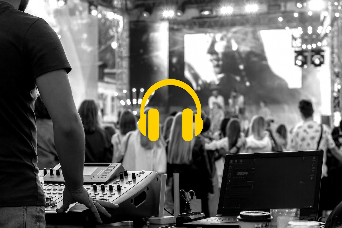 Tecnico del suono che regola un mixer audio durante un evento live